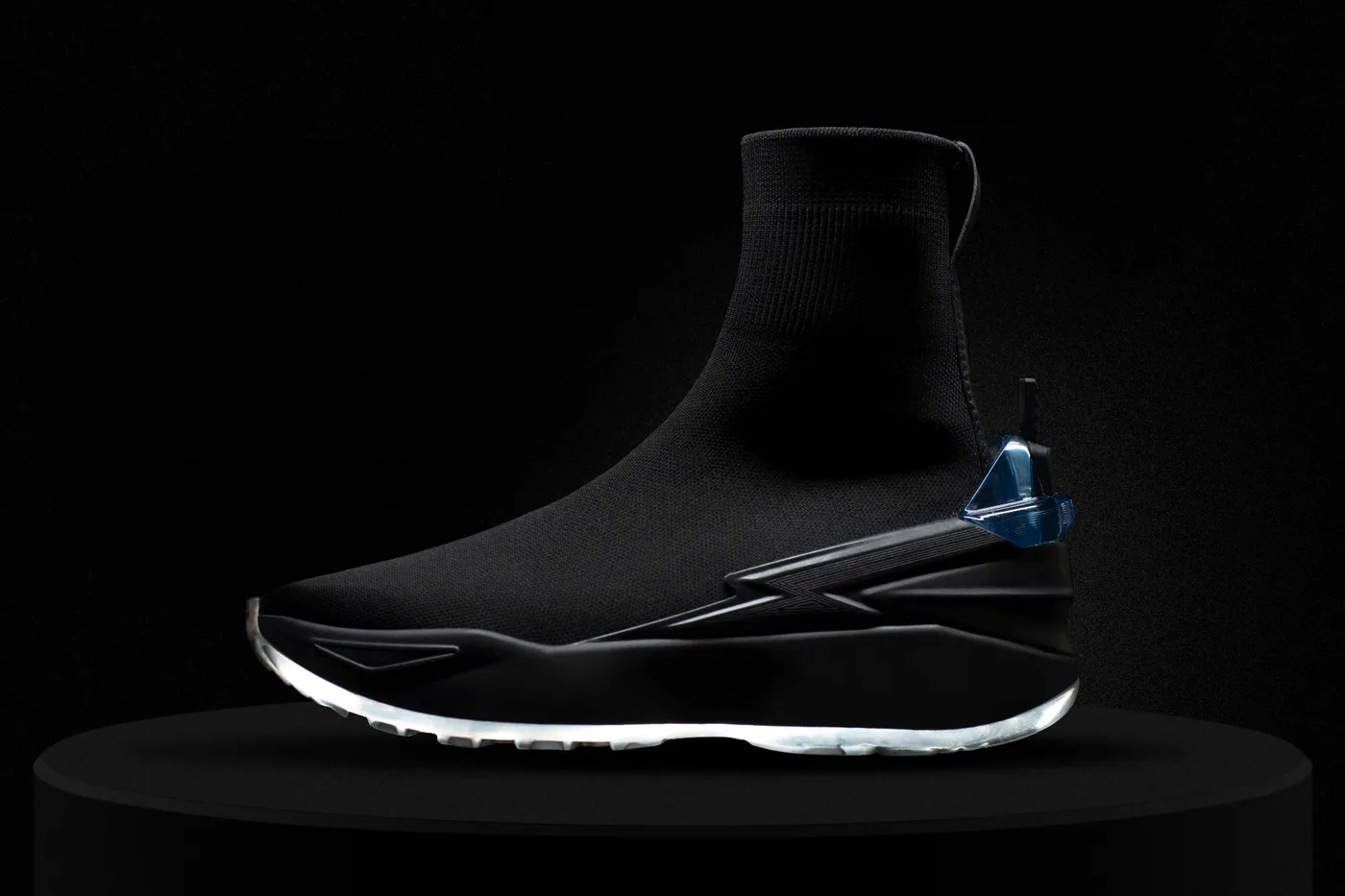 The MOONWKR sneaker by Gaian, shot on black with an illuminated sole.
